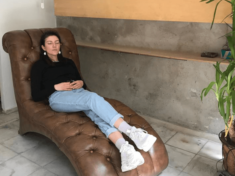 Participant reclining on a leather chaise longue while listening to an imagined dream, Dreams That Money Can Buy, 2019