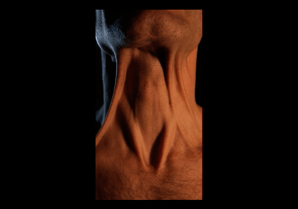 Video still from pathos: a human throat lit in orange against a black background