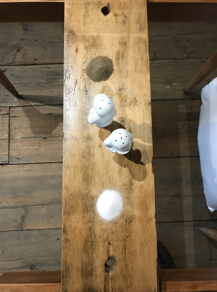 Top view of the narrow table with salt shakers and salt in masada... / on the table
