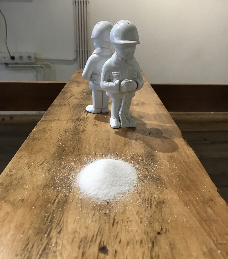 Soldier-shaped salt shakers beside a heap of salt on the table in masada...