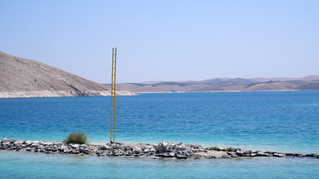 Ladder of Rising standing on a rocky islet with mountains behind