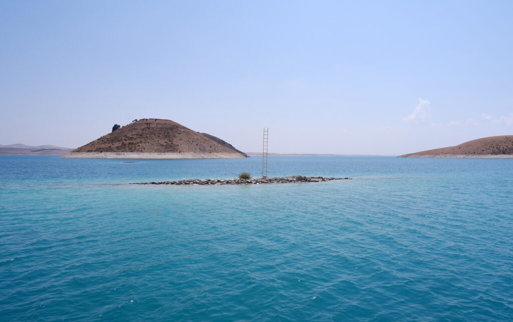 Islet with the ladder of Rising in the turquoise dam lake near Mount Nemrut