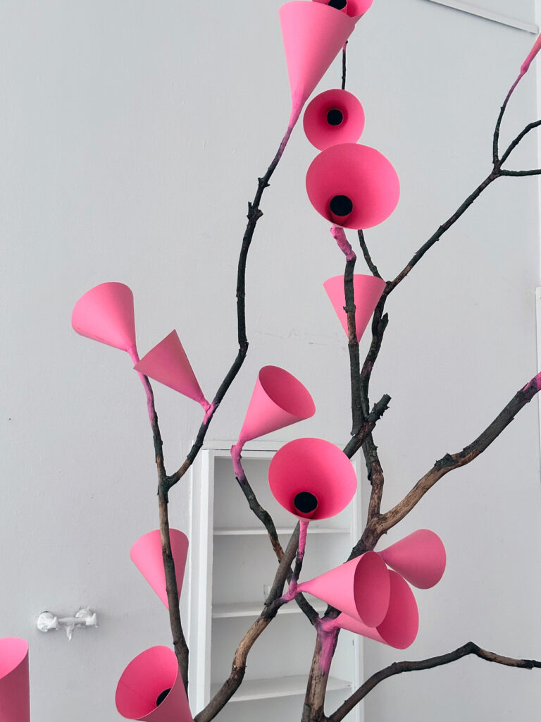 Close-up of the pink and red cone forms on the branches of the installation