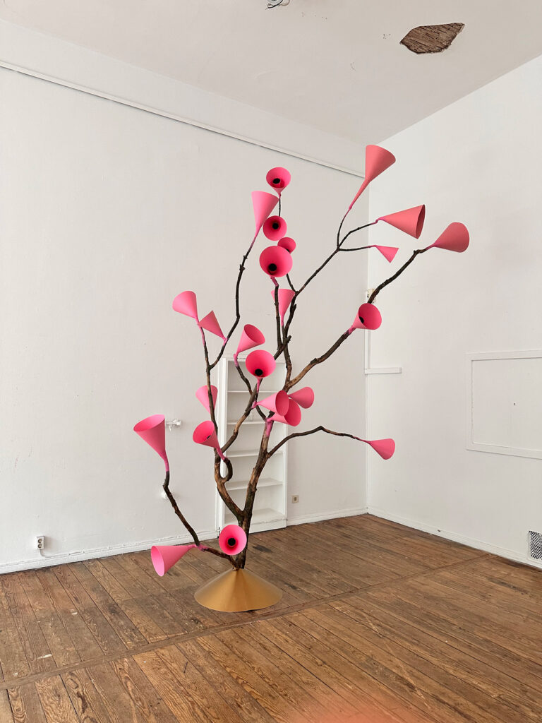 Branch sculpture with pink paper cones standing in a white studio, a trip at the Bethanien / repetition